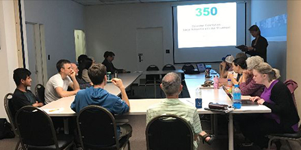 a group of volunteers sitting inside a room before a powerpoint presentation