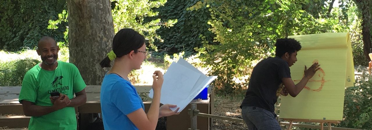 three people working on a community mapping activity outdoors
