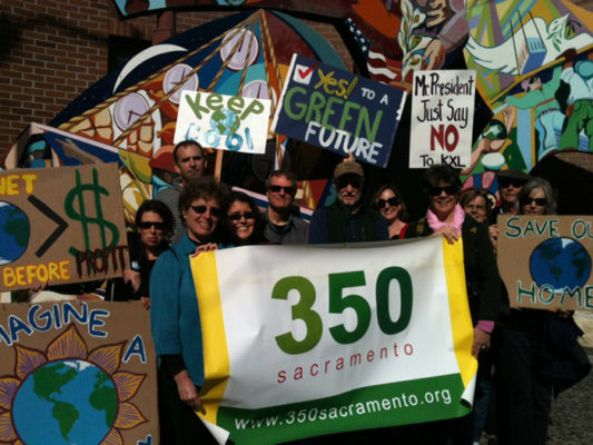 volunteers at a march holding a 350 Sacramento banner